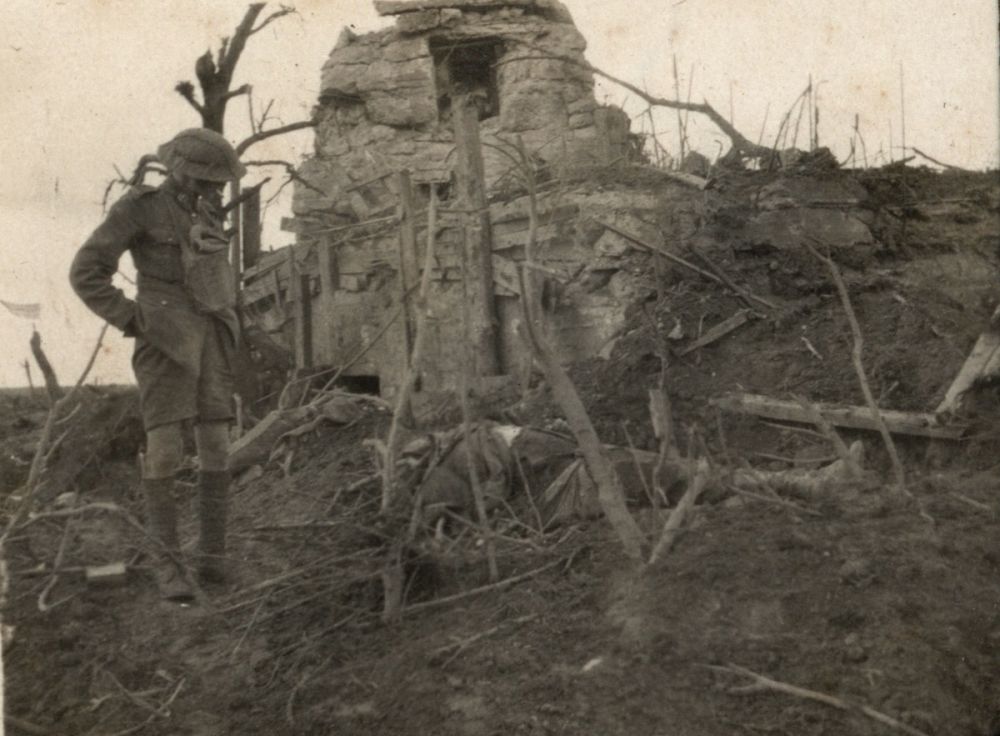 A New Zealand Lance Corporal casually stands by the corpse of a fallen soldier (probably German) on Gravenstafel Ridge, Passchendaele.